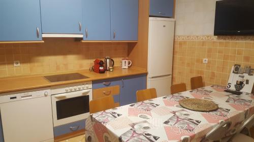 eine Küche mit einem Tisch und einem Tischtuch darauf in der Unterkunft Apartamento Amplio y Central a pie de Playa la Concha in San Sebastián