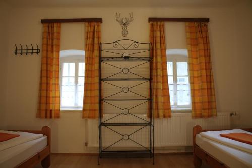 a bedroom with two windows and a book shelf at Buchschneider - Ferienhaus Maier - Landhof in Schwarzautal