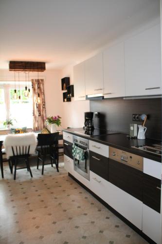 eine Küche mit schwarzen und weißen Geräten und ein Esszimmer in der Unterkunft Buchschneider - Ferienhaus Maier - Landhof in Schwarzautal
