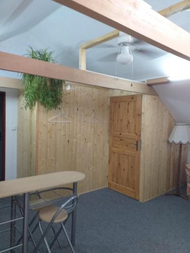a room with a table and chairs and a wooden wall at Vila Terezie in Staré Splavy