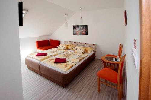 a bedroom with a bed and a chair at Fehér Hajó Panzió és Vendéglő in Győr