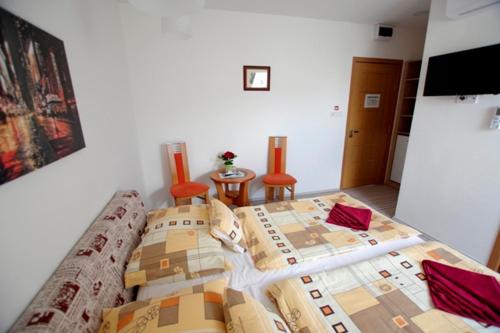 a bedroom with a bed with boxes on it at Fehér Hajó Panzió és Vendéglő in Győr