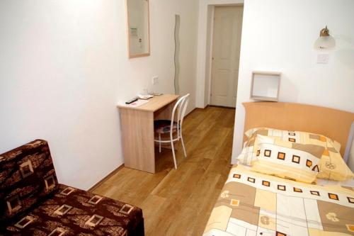 a small room with a bed and a desk at Fehér Hajó Panzió és Vendéglő in Győr
