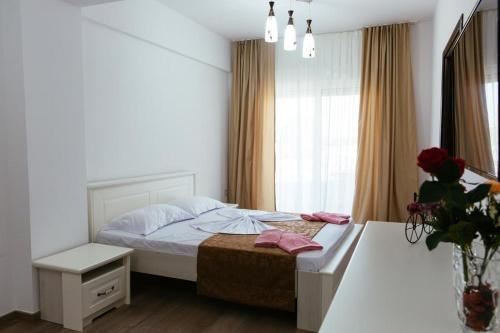 a white bedroom with a bed and a window at Sole Mio in Donji Štoj