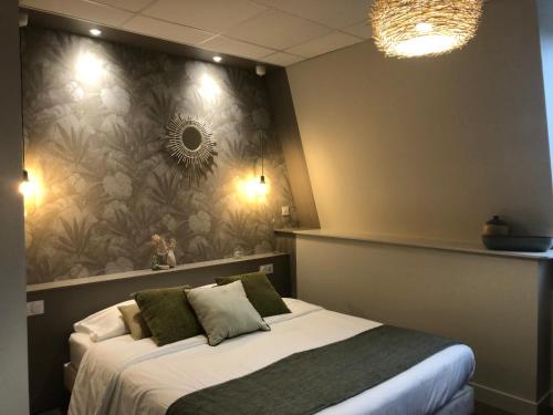 a bedroom with a bed and a flower wall at Cit'Hotel Les Alizes in Dinard