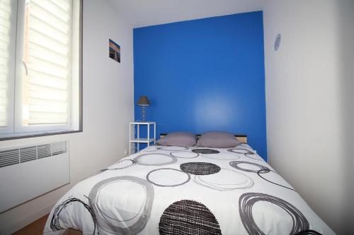 una camera da letto con un letto con una parete blu di Santorini a La Fère