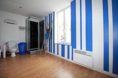 a bathroom with a blue and white striped wall at Santorini in La Fère