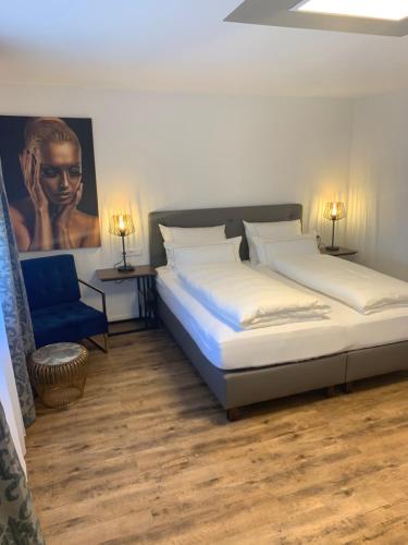 um quarto com 2 camas e uma cadeira azul em CityApartments Residence klimatisiert em Friedrichshafen