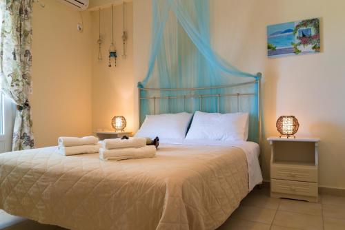 um quarto com uma cama com toalhas em Avelia Blue em Asprogerakata