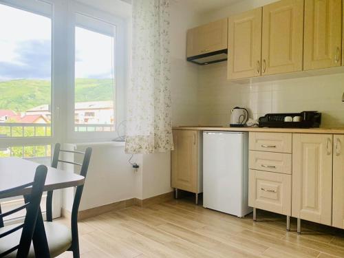 une cuisine avec une table et une table ainsi qu'une fenêtre dans l'établissement Апартаменти Monte, à Rakhiv