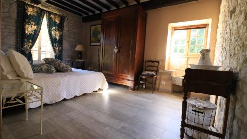 a bedroom with a bed and a desk and a window at Chambre d'hotes la Quercynoise in Montaigu-de-Quercy