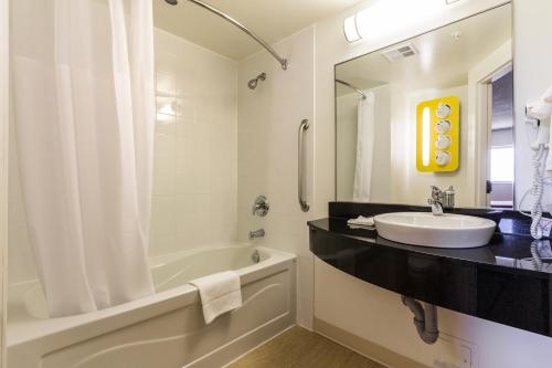 a bathroom with a sink and a bath tub and a sink at Motel 6-Kingston, ON in Kingston