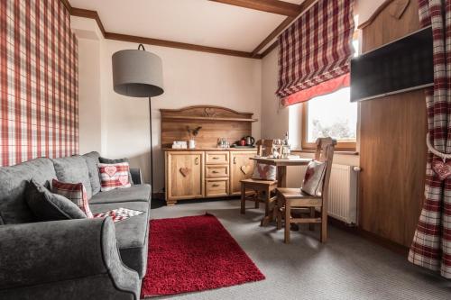 a living room with a couch and a table at Villa Adamo & Relax in Zakopane