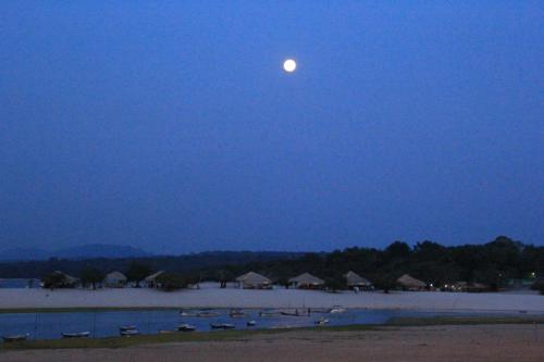 a full moon rising over a beach at night at Agualinda Hotel in Alter do Chao