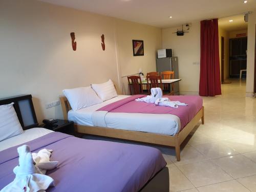 two beds with stuffed animals on them in a room at Chaiyapoon Inn in Pattaya Central