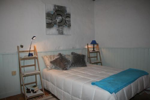 a bedroom with a white bed with two chairs at Casa Mamatita in Agüimes