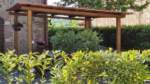 a wooden pergola in a garden with plants at La Limonaia Country House in Monteriggioni