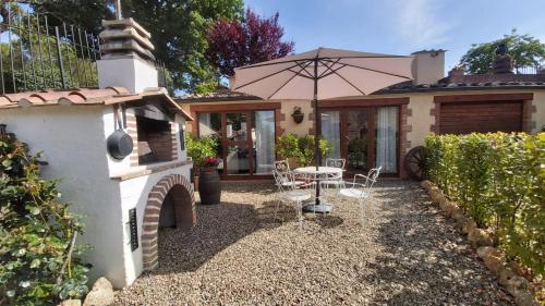 a patio with a table and an umbrella at La Limonaia Country House in Monteriggioni