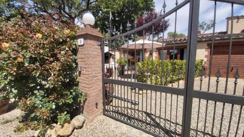 a gate with a brick pillar with a clock on it at La Limonaia Country House in Monteriggioni