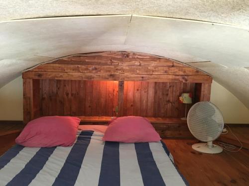 een slaapkamer met een bed met 2 kussens en een ventilator bij Repaire de Barberousse de Gruissan in Gruissan