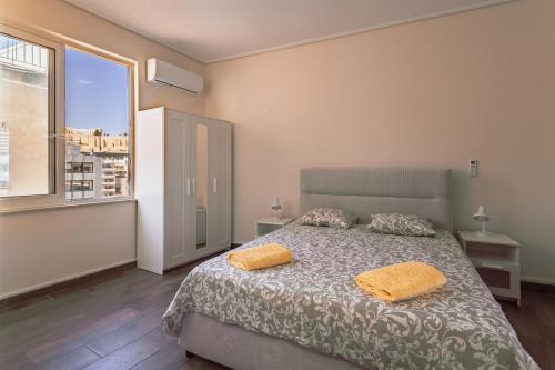 a bedroom with a bed and a large window at Acropolis comfy home in the heart of Athens for 4 in Athens