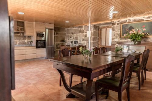 a kitchen and dining room with a wooden table and chairs at Casa dos Muiños in Pontevedra