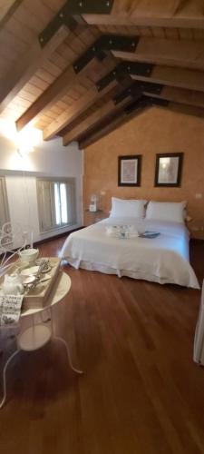 a bedroom with a white bed and a wooden floor at B&B Casa del Teatro in Mantova