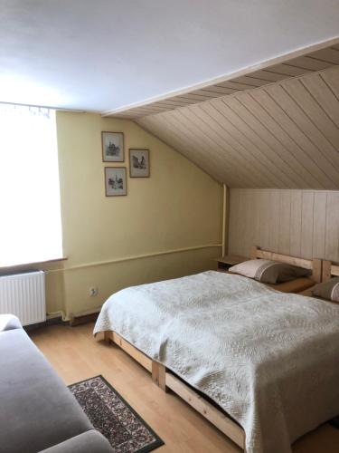 Un dormitorio con dos camas y una gran ventana. en Willa Emi, en Karpacz