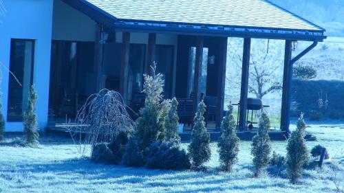 a house with a gazebo with trees in the yard at Holiday House Koceri in Ķekava