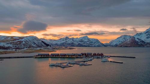 a group of boats in the water with mountains at Lilleeideholmen Sjøhusutleie in Haug
