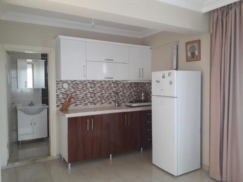 een keuken met een witte koelkast en een wastafel bij YALÇINKAYA PANSİYON in Burhaniye