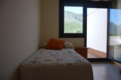 1 dormitorio con cama y ventana grande en Apartamento El Collau, en Posada de Llanes