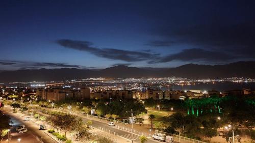 a view of a city at night with lights at Presidential Penthouse in Eilat