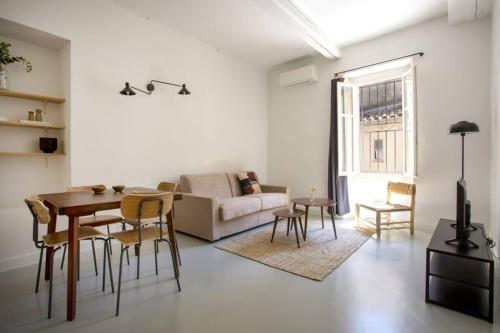 un salon avec un canapé, une table et des chaises dans l'établissement Plage à pied au cœur du vieil Antibes, à Antibes