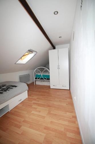 - une chambre avec un lit, une armoire et du parquet dans l'établissement la fere du siècle, à La Fère