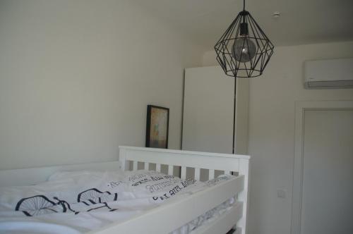 a bedroom with a white bed and a lamp at Kirschbluetenappartements in Breitenbrunn