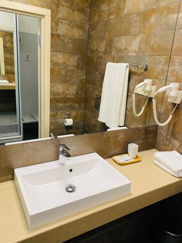 a bathroom with a white sink and a mirror at Status Hotel in Poltava