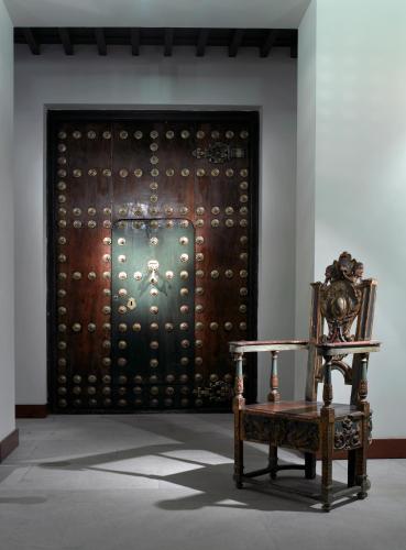 a room with a chair in front of a door at Parador de Granada in Granada