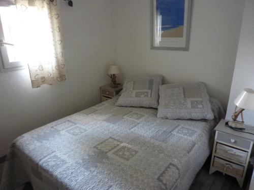 une chambre avec un lit avec deux tables de nuit et une fenêtre dans l'établissement Mas Provençal, au Lavandou