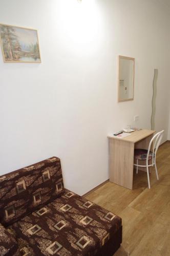 a bedroom with a desk and a bed and a table at Fehér Hajó Panzió és Vendéglő in Győr