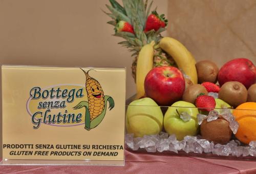 a bowl of fruit on a table with a sign at Best Western Hotel Globus City in Forlì