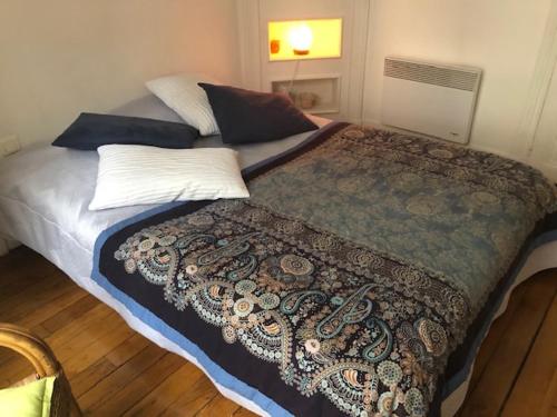 een slaapkamer met een groot bed met een deken erop bij Appartement Opéra Paris in Parijs