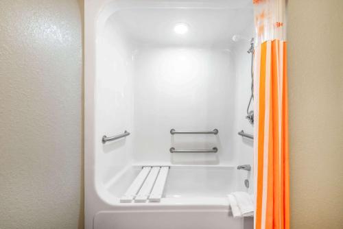a bathroom with a bath tub with an orange shower curtain at La Quinta by Wyndham St. Petersburg Northeast *Newly Renovated in St. Petersburg