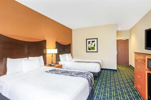 a hotel room with two beds and a flat screen tv at La Quinta by Wyndham Manassas Battlefield in Manassas