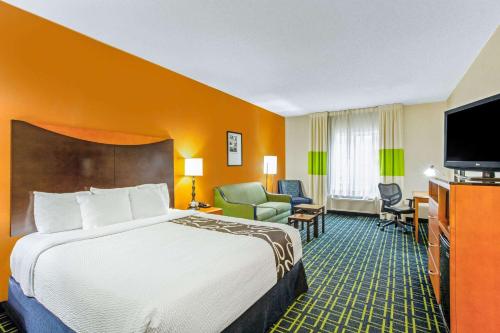 a hotel room with a bed and a flat screen tv at La Quinta by Wyndham Manassas Battlefield in Manassas