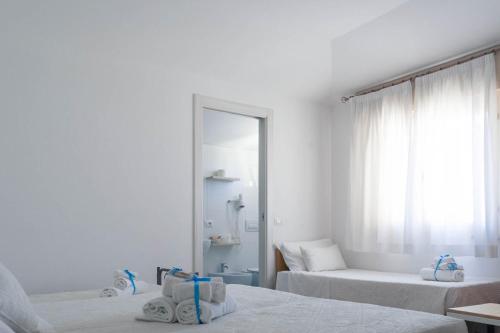 a white room with two beds and a mirror at Albergo Medusa in Punta Marina