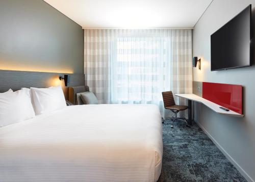 a hotel room with a bed and a tv at Holiday Inn Express Melbourne Southbank by IHG in Melbourne