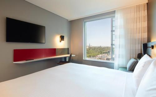 a hotel room with a bed and a large window at Holiday Inn Express Melbourne Southbank by IHG in Melbourne
