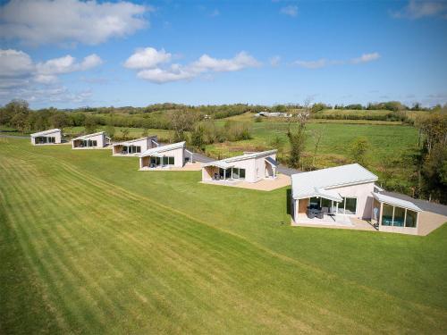 a row of white houses on a green field at Executive Lakeside Lodge at Mullans Bay in Kesh