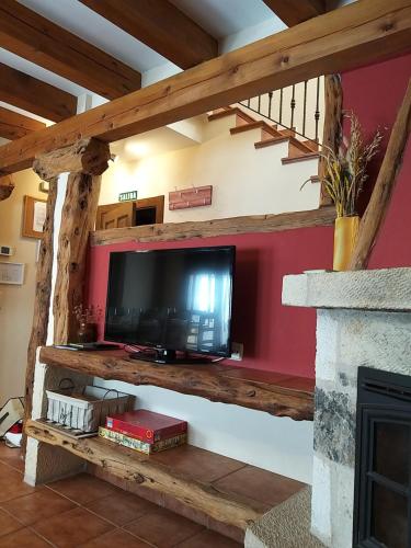 a living room with a flat screen tv on a wall at Casa Rural LA FUENTONA in Valle de Tabladillo